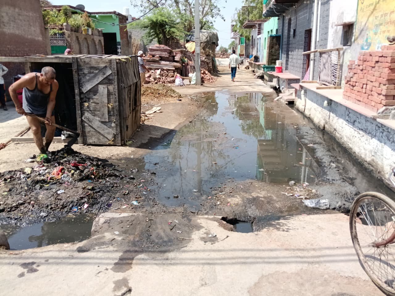 किरावली: नगला बहरावती में विकास कार्यों पर सवाल; आधी गली में सड़क न बनने से भारी जलभराव, खुद सफाई करने को मजबूर ग्रामीण